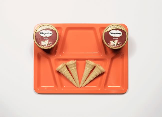Vemos la bandeja naranja donde vemos dos cajas de  helado y cuatro conos o barquillos 