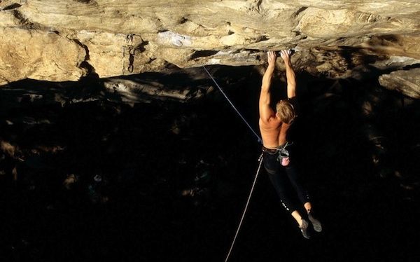 Un hombre cuelga peligrosamente de la pared rocosa de una montaña
