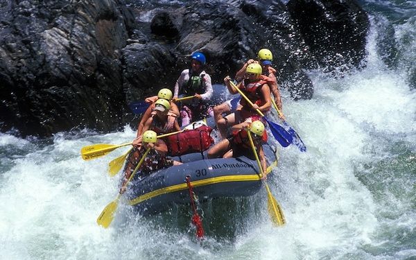 Seis personas en un bote luchan contra las aguas salvajes de un río