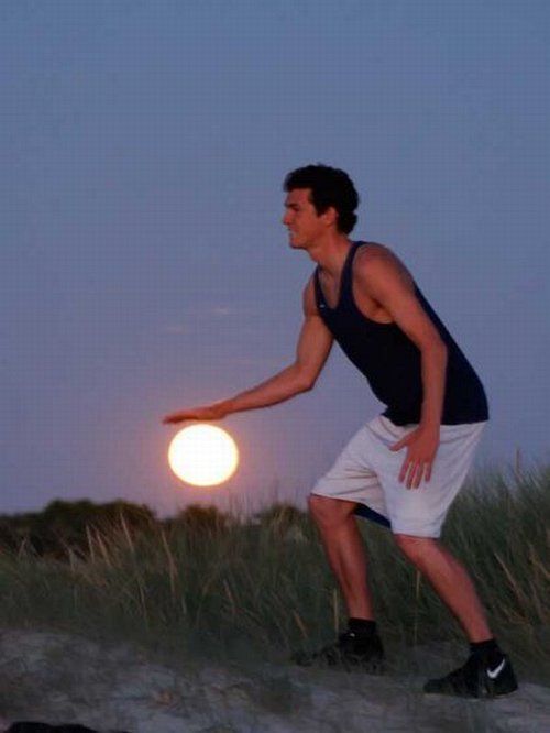 Vemos a un hombre joven con uniforme de baloncesto que simula jugar con  luna como balón 