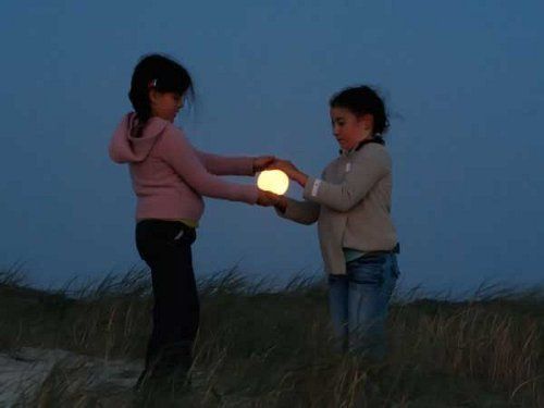 Tenemos dos niñas pequeñas  que parecen que tomaran la luna entre sus manos 