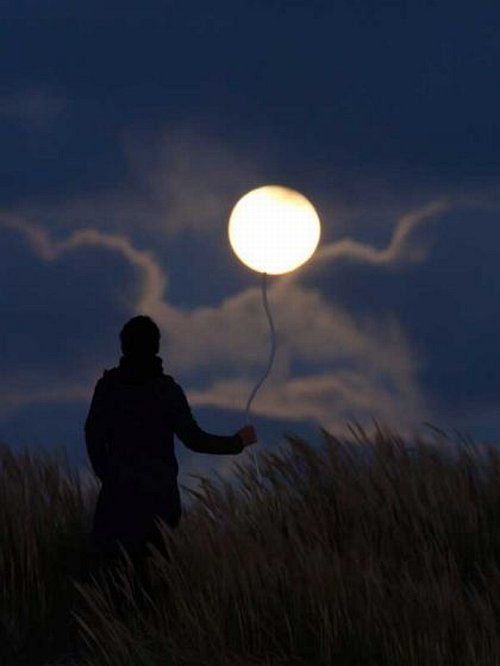 Una  persona en un campo le coloca una cinta a la luna  