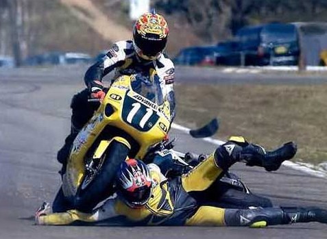 Estamos viendo como un motociclista en competencia atropella a otro competidor con su moto que yace en el suelo