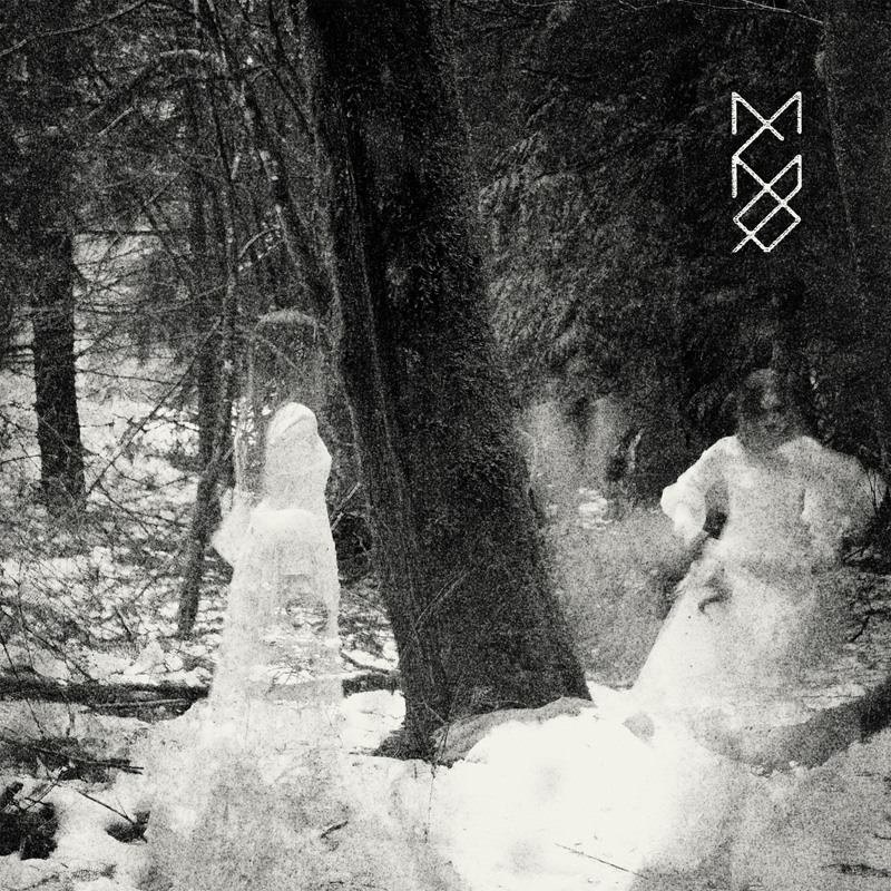 Una arboleda y una mujer en traje de novia y su imagen se proyecta al frente de ella  en medio de la bruma