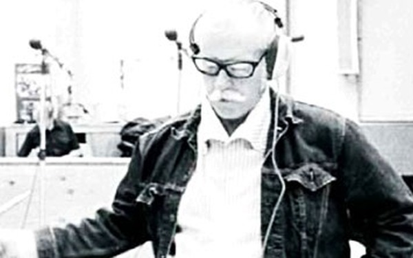 Un hombre de edad con gafas y auriculares mirando hacia abajo
