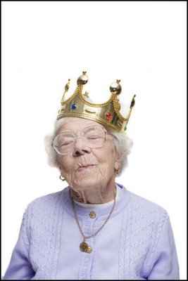 Vemos la abuela con una gran corona dorada con piedras incrustadas y una  exprecion de serena