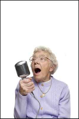 la abuela con pelo blanco y sus gafas con un micrófono antiguo canta muy feliz