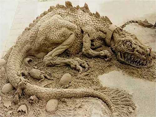 Vemos un dinosaurio hecho en arena en arena se ven muy bien sus partes    y vemos tambien huevos abriendo de onde salen pequños dinosaurio 