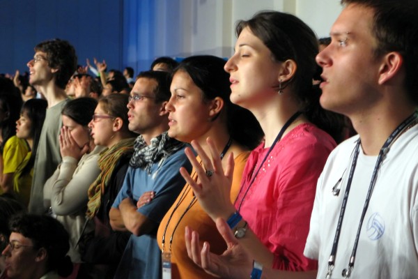 Vemos a muchos jóvenes  orando y alsando sus manos
