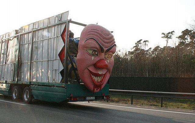 Vemos un camion que lleva una gran mascara atras que esta sonrie 