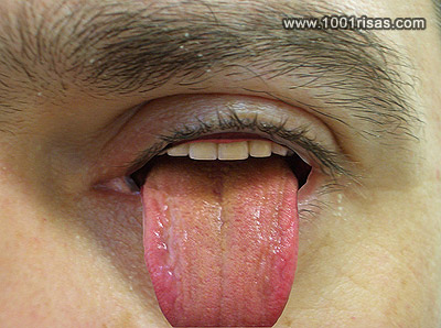 Vemos a una ceja y debajo el ojo y del ojo sale una lengua muy roja y dientes en el parpado superior