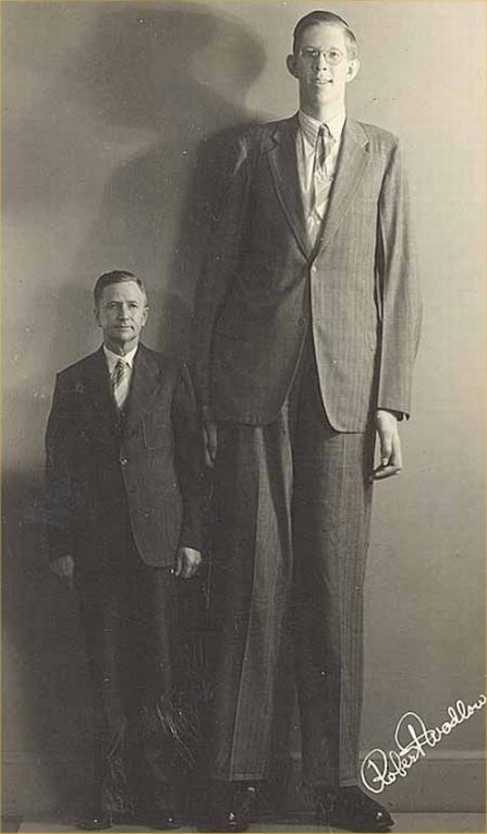 Vemos el hombre  demasiado alto con otro de un tamaño normal 