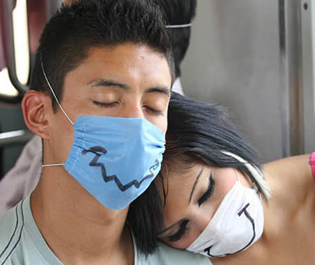 Una pareja con tapabocas a los que les han pintado bocas con marcador negro