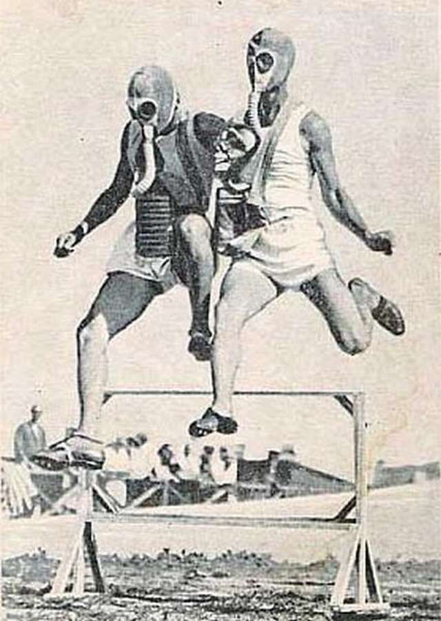 Vemos a dos hombres  con mascaras anti-gases y traje de deporte saltan  en una competencia