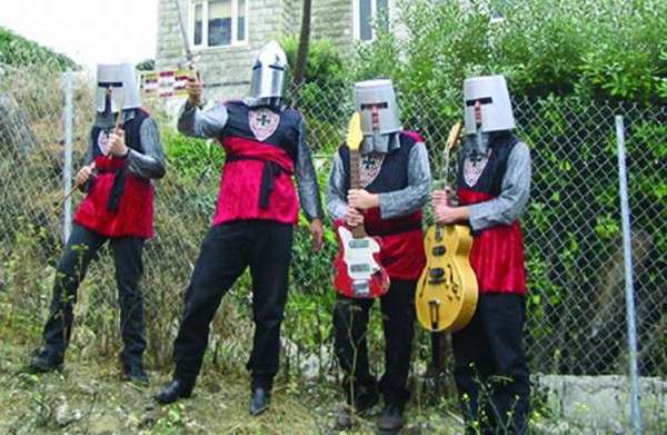 Una banda de cuatro músicos con guitarras y extraños sombreros de lata en sus cabezas 