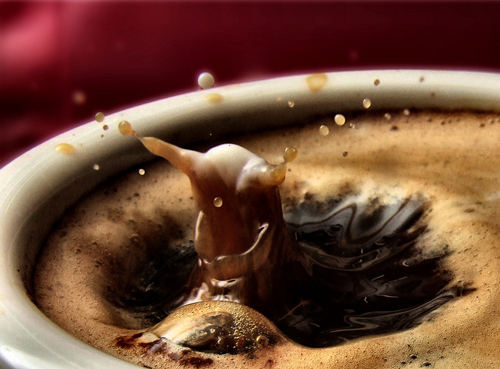Tenemos una taza con café que da la sensación que unas burbujas  hacen la figura de ave acuatica y dentro otra estuviera sumerguida