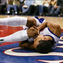 En el suelo vemos a un basquetbolista llorando por un fuerte dolor de rodilla