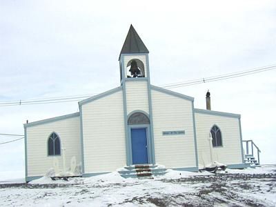 Vemos a una modesta iglesia con su campanario en color azul y blanco
