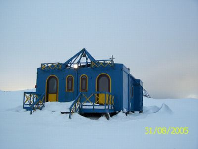 Vemos una pequeña iglesia en medio de la nieve  en color azul y amarillo