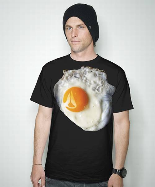 Vemos aun hombre con una camiseta negra donde vemos aun huevo frito en su pecho