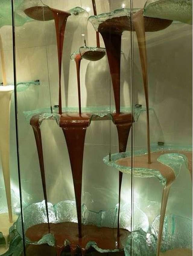 Ahora vemos el chocolate café  cuando cae en hermosas copas  de vidrio