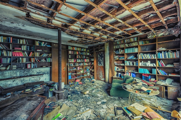 Una biblioteca sin cielorazo, hay libros por todo lado y hay mucha basura