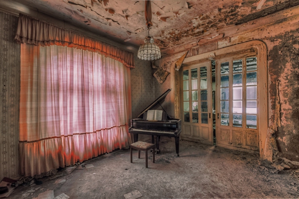 Un cuarto con las paredes derrocadas en el cual hay un piano es una esquina