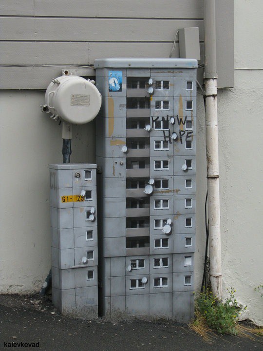 Un edificio plasmado en una puerta de donde sacan conexiones para la electricidad