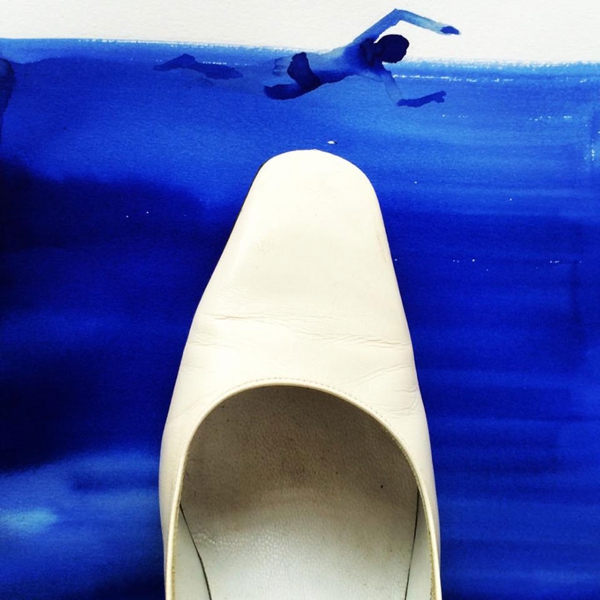 Hombre nadando en agua azul y también un zapato  blanco flota alli
