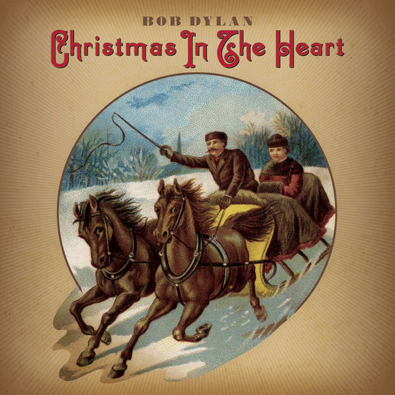 Dos personas en un trineo sobre la nieve impulsadas por dos caballos  dentro de un círculo y donde se lee en inglés navidad en el corazón