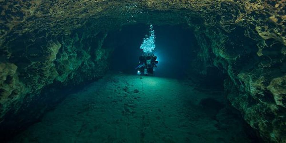 Un hombre buceando en lo profundo de una cueva submarina