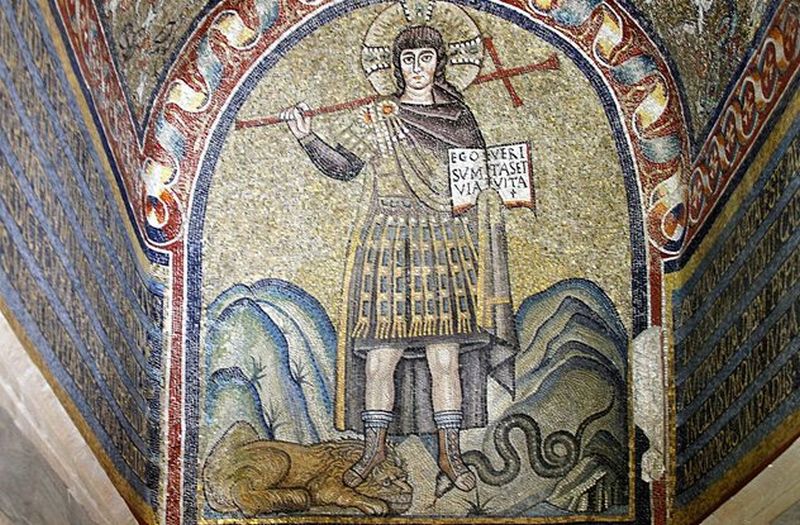 Imagen de u hombre sosteniendo una cruz mientras pisa un león y una serpiente