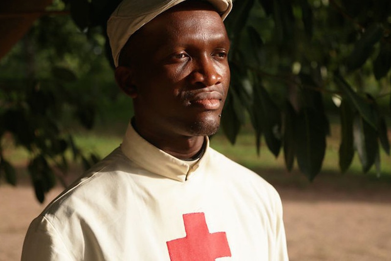 Un sacerdote vestido con un traje que lleva el símbolo de la Cruz Roja en su pecho