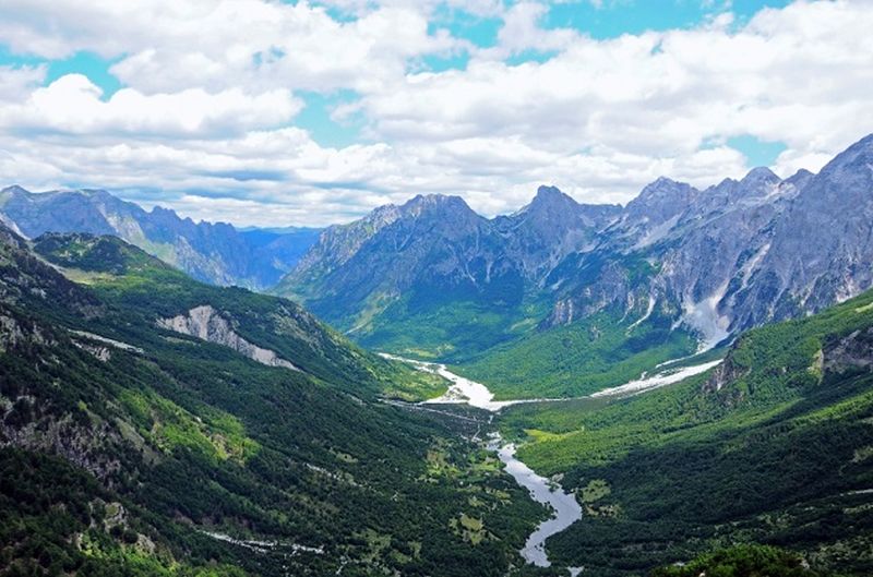 Imagen panoramica con montañas a los lados y un río en la mitad