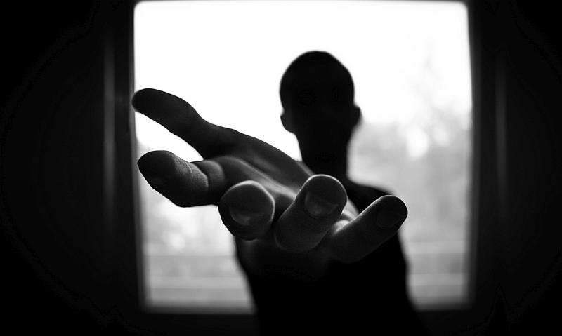 Vemos la figura de un hombre a través de una ventana pero lo unico que se ve bien sus manos estiradas