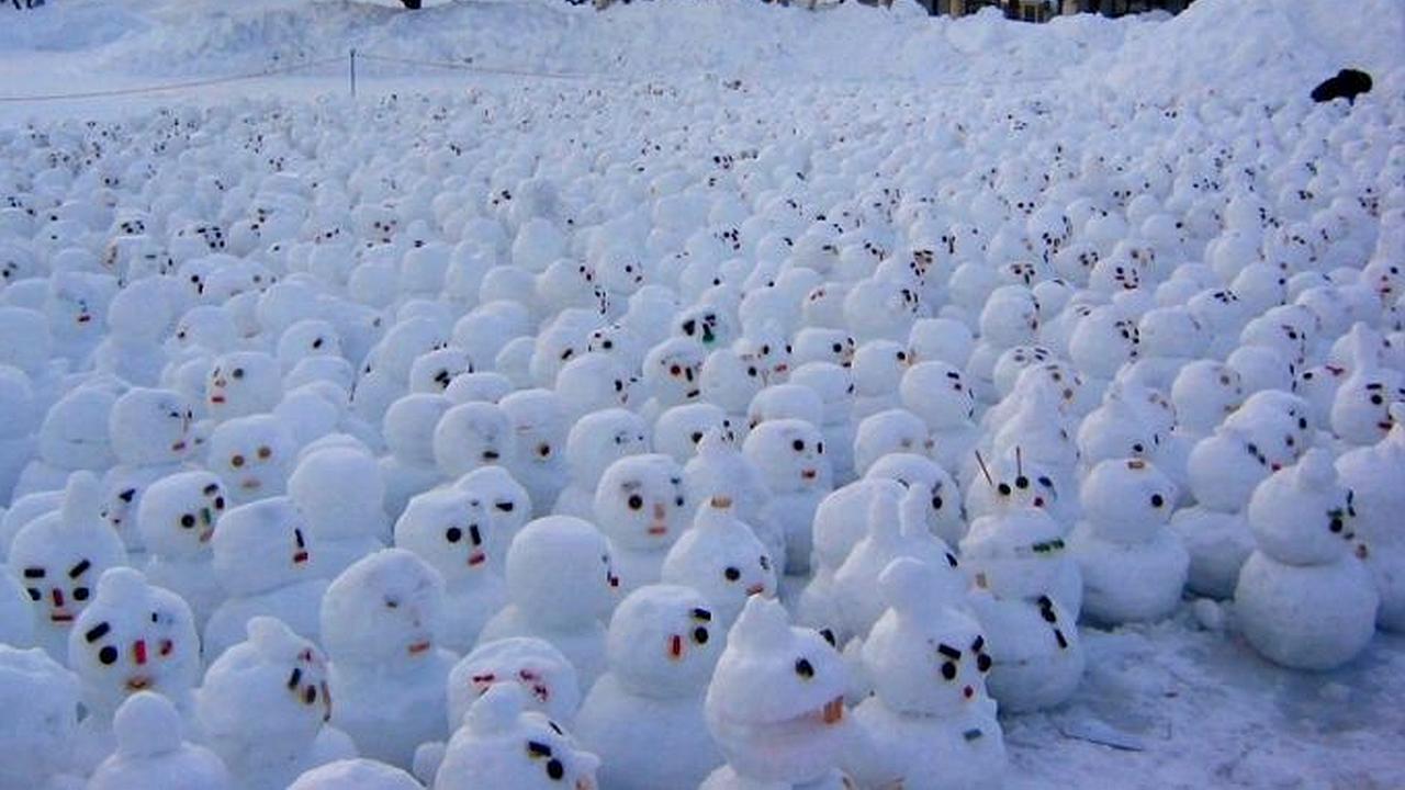 Muchos muñequitos de navidad hechos de nieve sobre la nevada