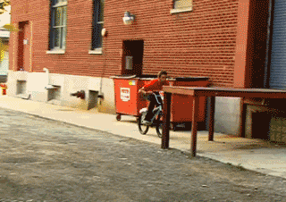 Un joven hace una acrobacia con una mesa y una bicicleta