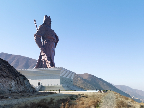 monumental estatua color gris sobre una colina en un gran pedestaly se divisa al fondo un gran valle.