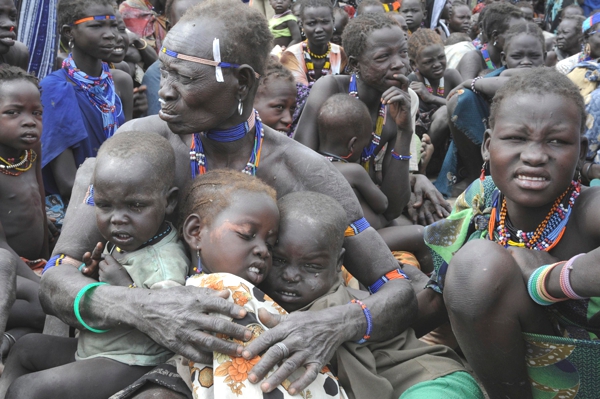 Un hombre africano abraza a sus hijos para protegerlos por algo que pasa