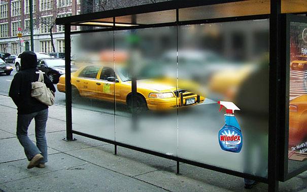 Vemos un taxi a traves de una vidrio que escibe publicidad en ese momento esta opaco el vidrio y el taxi se ve poco vemos grabado el nombre de un producto limpia vidriod