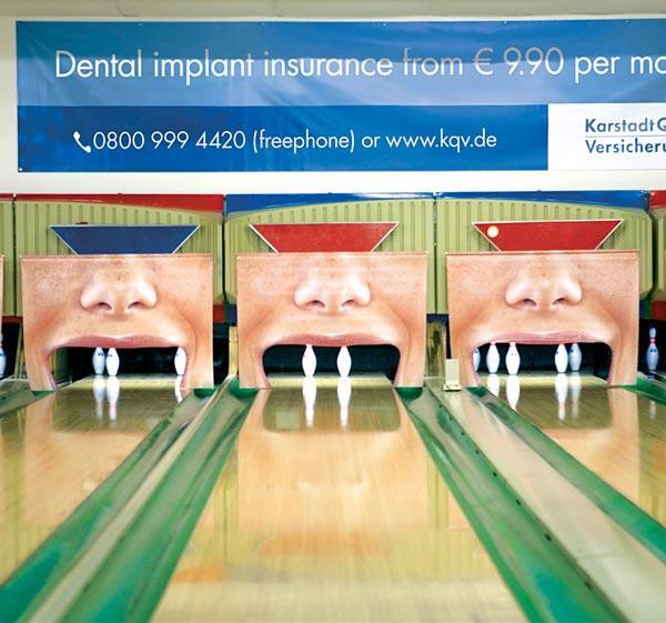 Vemos unas canchas de Bolos donde los boliches simulan dientes perdidos para publictar implantes dentales