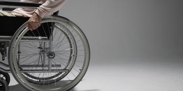 Una persona sentada en su silla de ruedas descansa