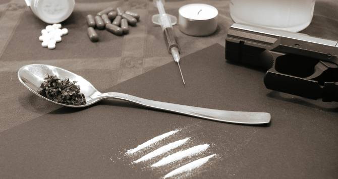 Drogas como la heroína, cocaína, crack, pastillas, y agujas lado a lado
