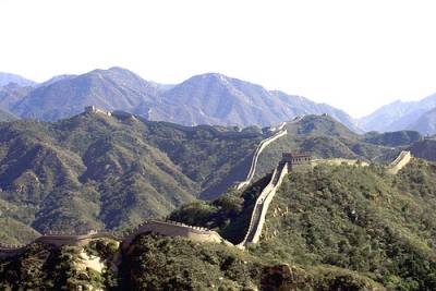 Vemos una cadena montañosa y sobre ella se ve una gran muralla que atraviesa  un largo tramo