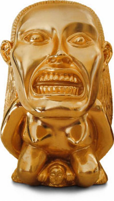 Vemos una mascara en color dorado   con ojos muy grandes y  muestra sus dientes 