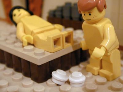 Unos muñecos unos muñecos uno recostado en una especie de cama y al lado el otro muñeco 