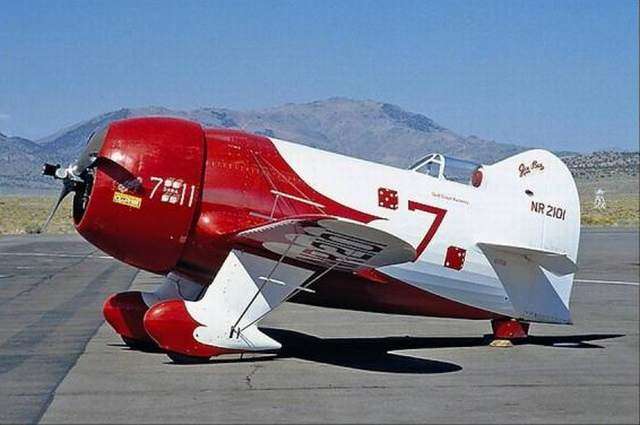Tenemos un avión en color rojo y blanco  con unas  llantas  muy pequeñas en un modelo muy antiguo o adaptado a l tiempos de hoy