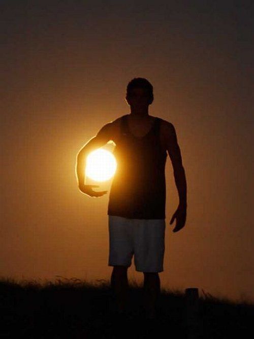 Un hombre joven en la noche parece que llevara la luna debajo su brazo