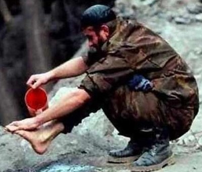 Observamos a un  soldado que lava un pie que no es el suyo por la forma en que se tomo la foto la persona del pie no aparece