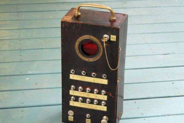 Vemos un calculadora antigua con manija para transportar y en color caoba y con muchos botones para usar